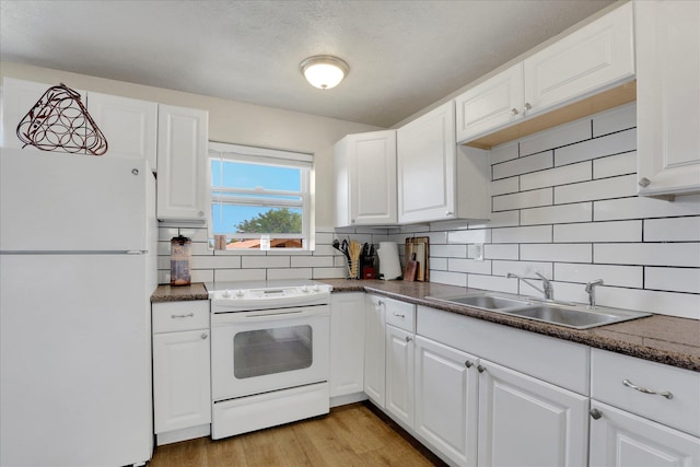 12017 E Mansfield Avenue ., Spokane Valley, WA 99206 - kitchen featuring decorative backsplash, white appliances, white cabinetry, and a sink