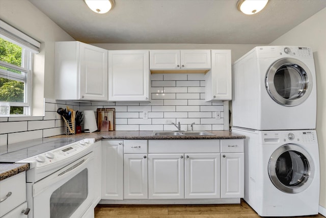 12017 E Mansfield Avenue ., Spokane Valley, WA 99206 - clothes washing area featuring a sink, stacked washer / drying machine, light wood-style floors, and laundry area