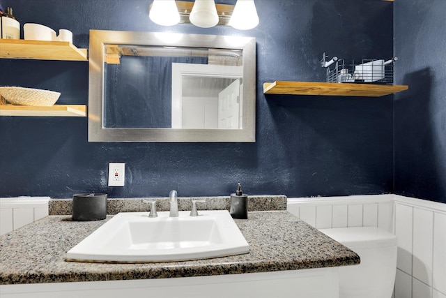 12017 E Mansfield Avenue ., Spokane Valley, WA 99206 - bathroom with vanity, a textured wall, and a wainscoted wall