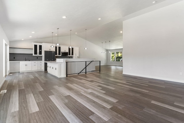 806 W Bolan Ave, Spokane, WA 99224 - unfurnished living room featuring vaulted ceiling, wood finished floors, recessed lighting, baseboards, and a sink