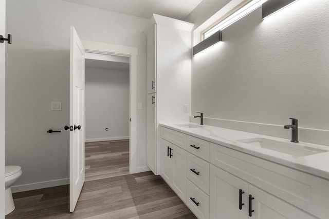 806 W Bolan Ave, Spokane, WA 99224 - full bathroom featuring toilet, wood finished floors, double vanity, and baseboards
