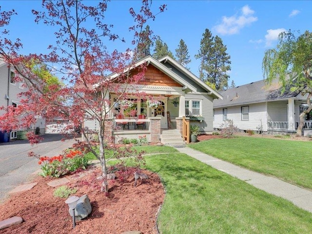 craftsman-style home with a porch and a front lawn