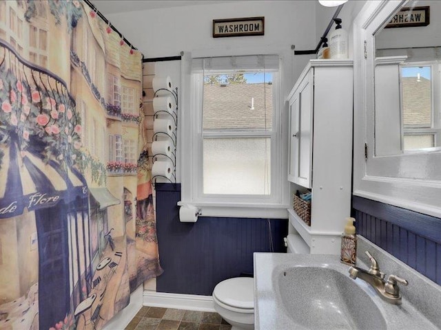bathroom with a sink, toilet, and baseboards