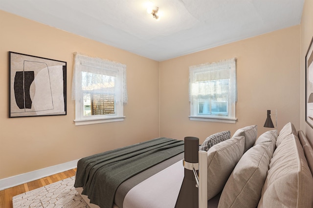 bedroom featuring baseboards and wood finished floors
