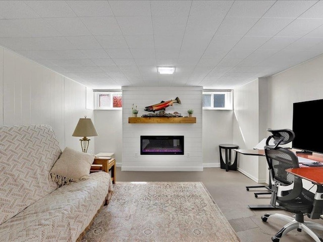 office featuring a glass covered fireplace and wood walls