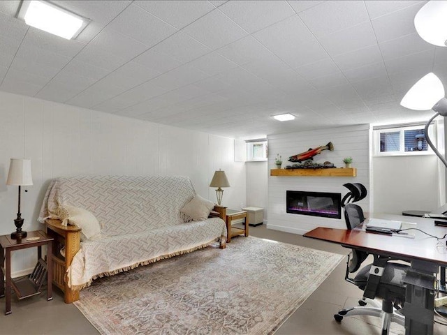 office space with a glass covered fireplace and finished concrete floors