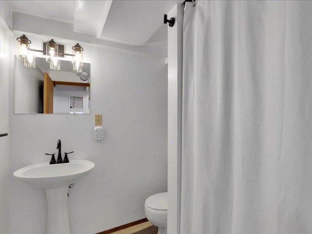 bathroom featuring toilet and curtained shower