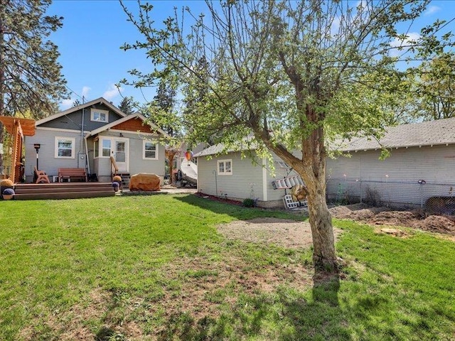 rear view of property featuring a lawn and a wooden deck