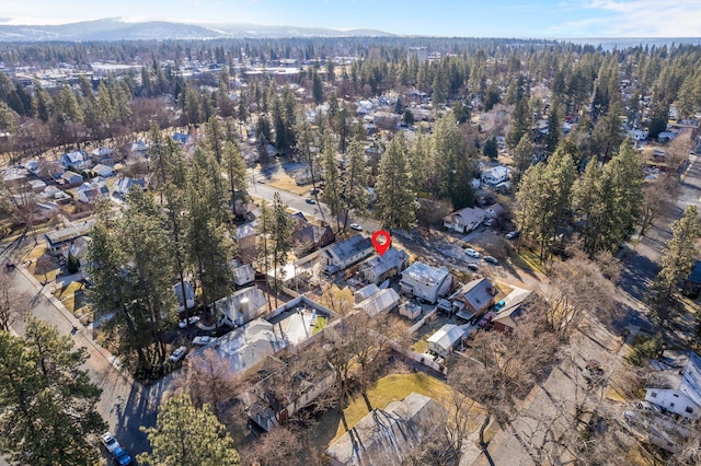 view of property location featuring nearby suburban area and a forest