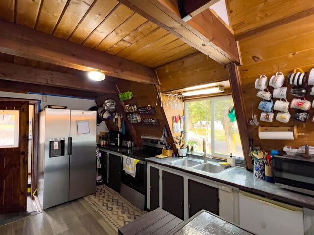 2063-A Marble Valley Basin Rd, Addy, WA 99101 - kitchen featuring appliances with stainless steel finishes, a sink, wood ceiling with exposed beams, wood finished floors, and wood walls