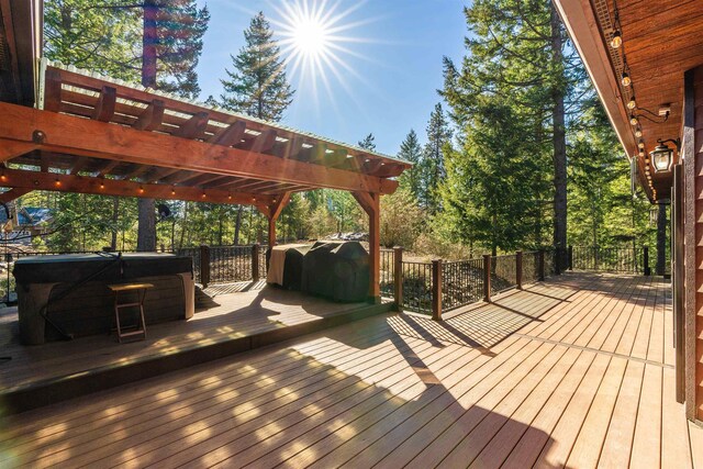 wooden terrace with a grill, a pergola, and a hot tub