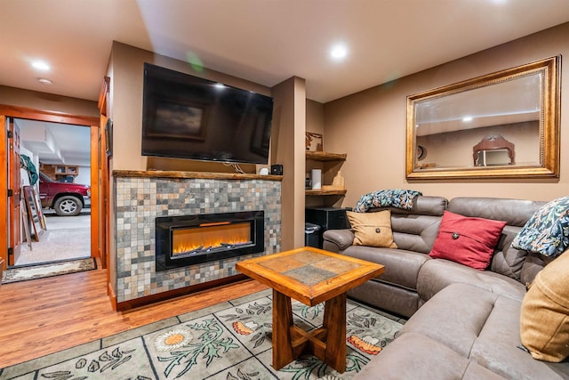 living room with recessed lighting, wood finished floors, and a tile fireplace