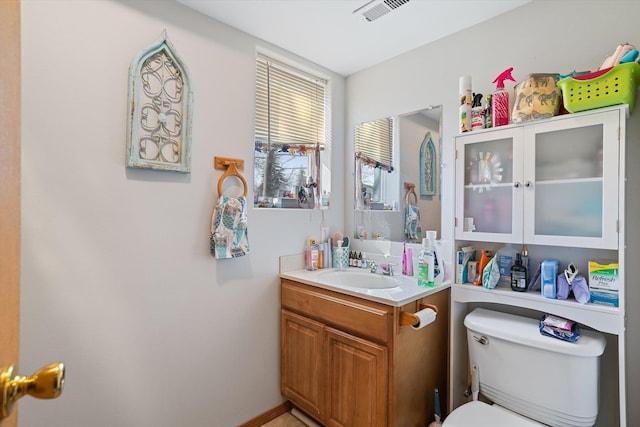 bathroom with vanity, visible vents, and toilet