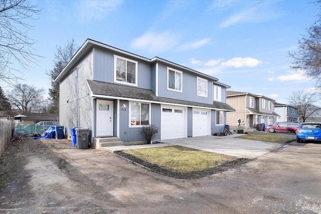 view of front of home with concrete driveway, a residential view, roof with shingles, an attached garage, and fence