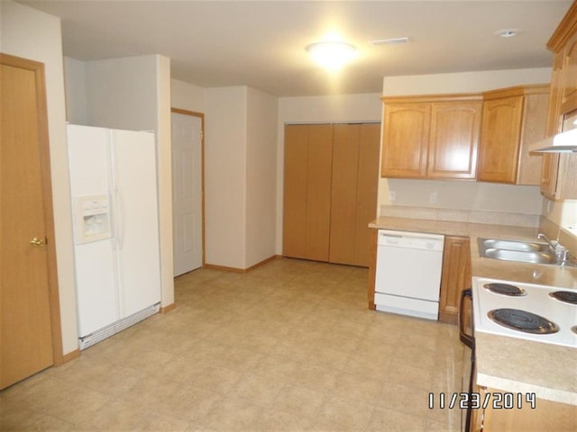 kitchen featuring a sink, light countertops, white appliances, under cabinet range hood, and light floors
