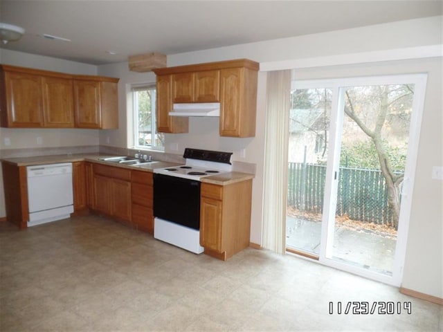 kitchen with under cabinet range hood, dishwasher, a sink, light countertops, and electric range oven