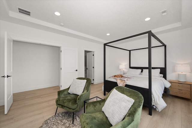 bedroom featuring light wood-style floors and visible vents