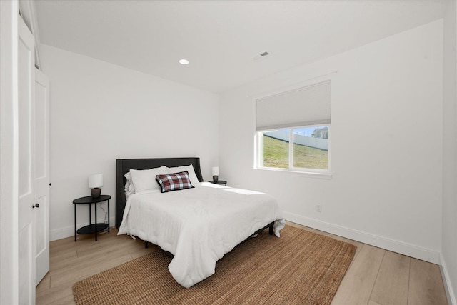 bedroom with recessed lighting, light wood-style flooring, and baseboards