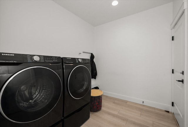 laundry area with wood finished floors, washing machine and dryer, baseboards, laundry area, and recessed lighting