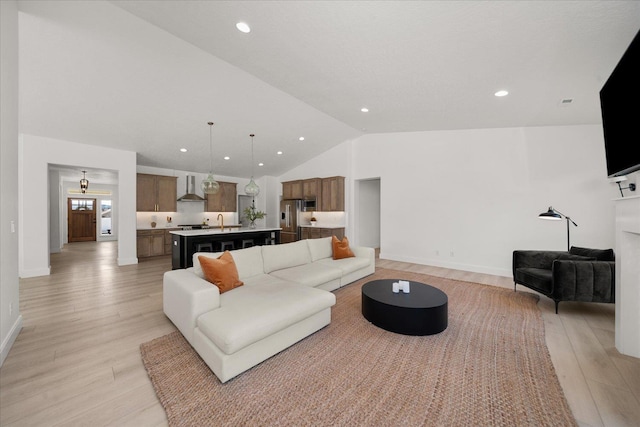 living area with lofted ceiling, light wood finished floors, and recessed lighting