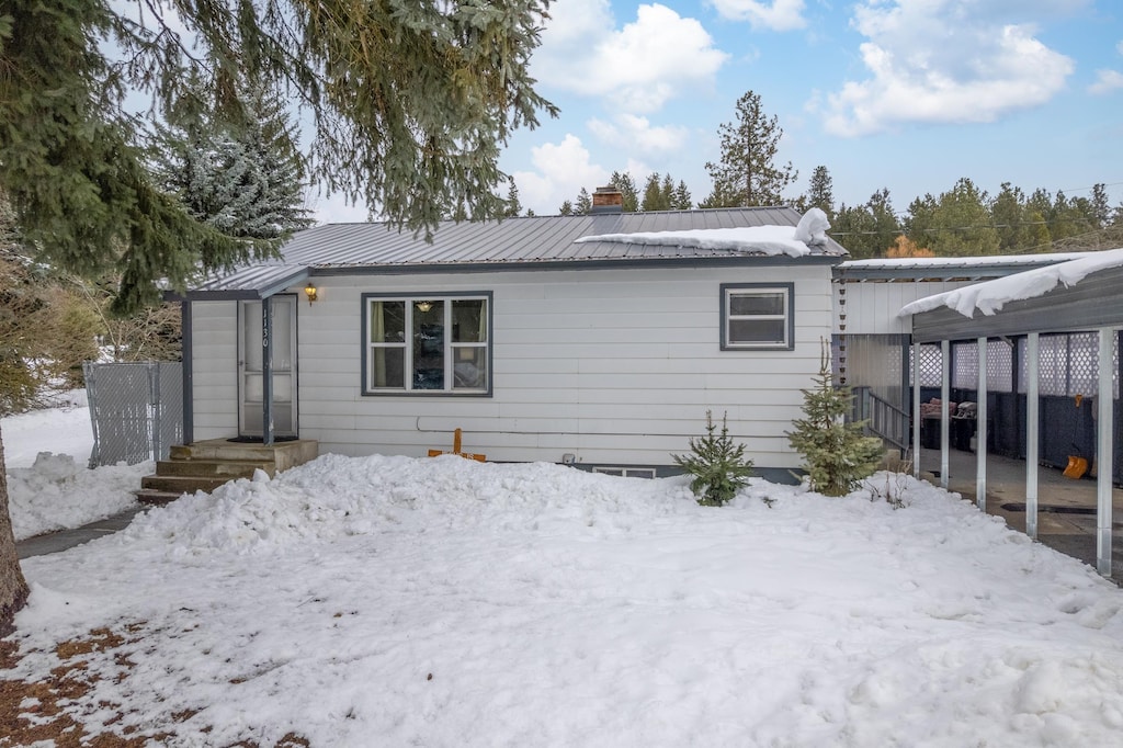 1130 W Spruce St, Newport, WA 99156 - snow covered property featuring fence, a chimney, and metal roof