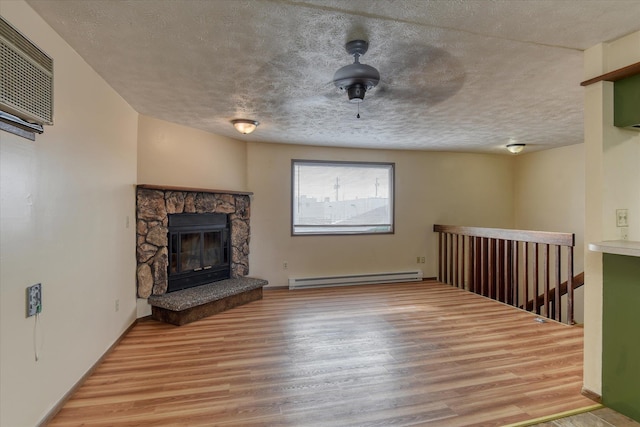 6208 N Wiscomb St, Spokane, WA 99208 - unfurnished living room with a baseboard radiator, wood finished floors, a stone fireplace, and a textured ceiling