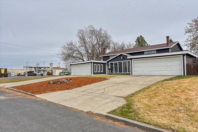 6208 N Wiscomb St, Spokane, WA 99208 - mid-century inspired home with concrete driveway, a front lawn, and a chimney