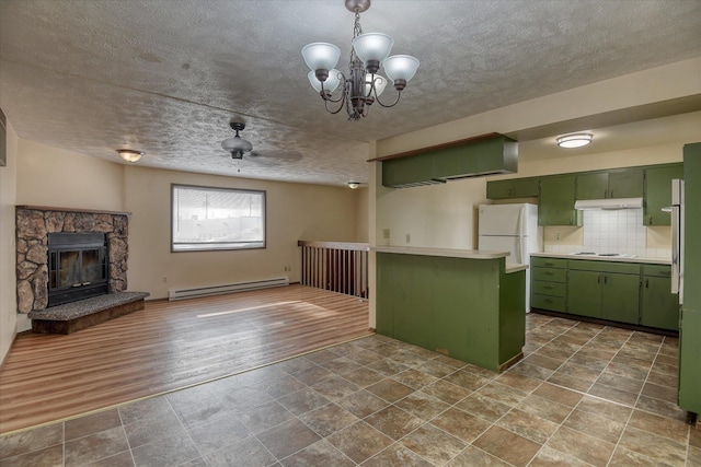 6208 N Wiscomb St, Spokane, WA 99208 - kitchen with green cabinets, a baseboard radiator, light countertops, cooktop, and freestanding refrigerator