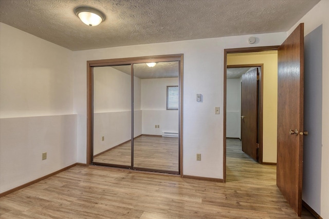 6208 N Wiscomb St, Spokane, WA 99208 - unfurnished bedroom featuring light wood-type flooring, a baseboard radiator, a textured ceiling, and a closet