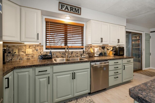 313 SE Trinity Ave, Wilbur, WA 99185 - kitchen featuring dishwasher, a sink, dark countertops, light wood finished floors, and a textured ceiling