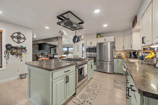 313 SE Trinity Ave, Wilbur, WA 99185 - kitchen featuring appliances with stainless steel finishes, green cabinetry, dark countertops, a sink, and recessed lighting