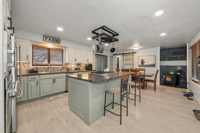 313 SE Trinity Ave, Wilbur, WA 99185 - kitchen featuring a sink, a barn door, a kitchen island, appliances with stainless steel finishes, and light wood-style flooring