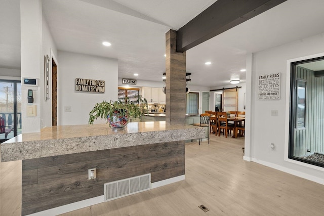 313 SE Trinity Ave, Wilbur, WA 99185 - kitchen featuring a barn door, light wood-style floors, baseboards, light stone countertops, and recessed lighting