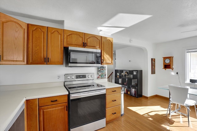 870 E 8th Ave, Colville, WA 99114 - kitchen featuring light wood-style flooring, appliances with stainless steel finishes, light countertops, and brown cabinetry