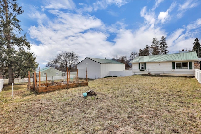 870 E 8th Ave, Colville, WA 99114 - back of property with an outdoor structure, metal roof, fence, a lawn, and a vegetable garden
