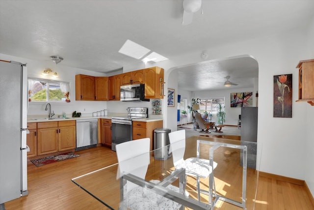 870 E 8th Ave, Colville, WA 99114 - kitchen featuring a ceiling fan, a healthy amount of sunlight, stainless steel appliances, arched walkways, and a sink