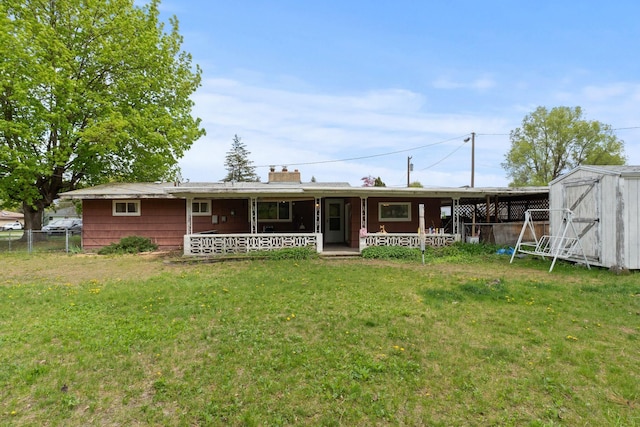 1804 S Blake Rd, Spokane Valley, WA 99216 - back of house with covered porch, a chimney, fence, a storage unit, and a yard