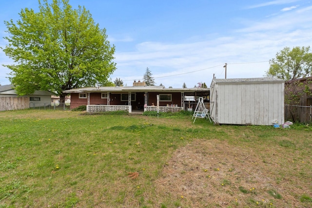 1804 S Blake Rd, Spokane Valley, WA 99216 - rear view of house with fence, a storage unit, a porch, an outdoor structure, and a yard