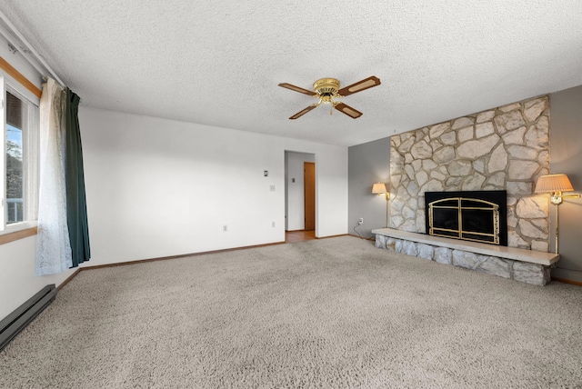 147 N Lindsey St, Tekoa, WA 99033 - unfurnished living room with carpet, a textured ceiling, a baseboard radiator, a ceiling fan, and a stone fireplace