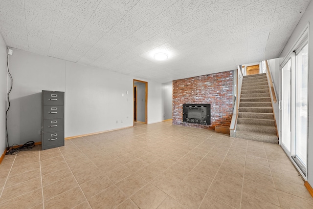 147 N Lindsey St, Tekoa, WA 99033 - unfurnished living room featuring light tile patterned floors, baseboards, stairway, and a brick fireplace