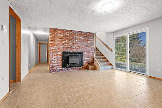 147 N Lindsey St, Tekoa, WA 99033 - unfurnished living room featuring tile patterned flooring, baseboards, a fireplace, and stairs