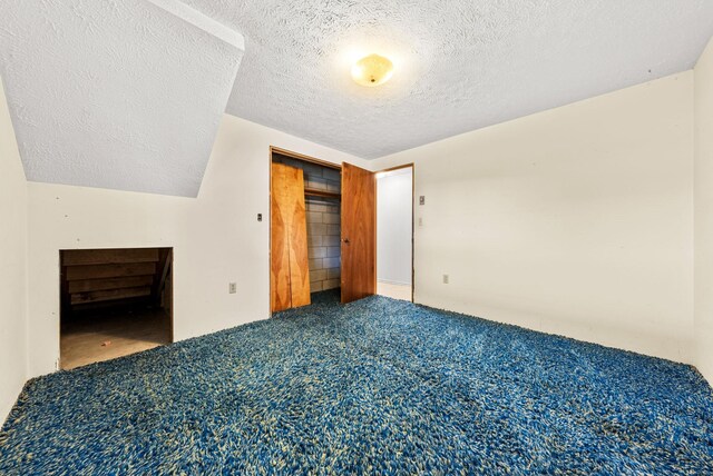147 N Lindsey St, Tekoa, WA 99033 - unfurnished bedroom with carpet flooring, a closet, vaulted ceiling, and a textured ceiling