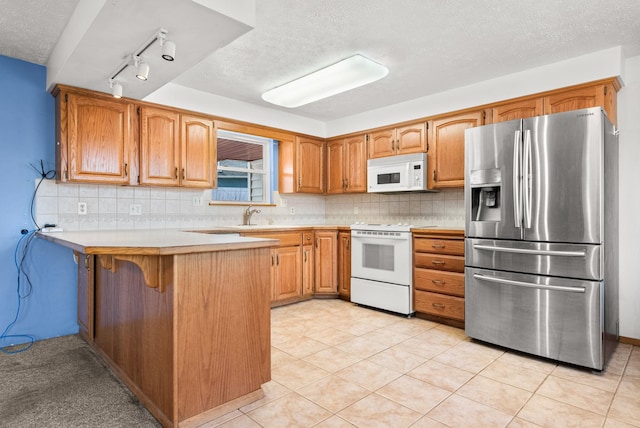 147 N Lindsey St, Tekoa, WA 99033 - kitchen with decorative backsplash, light countertops, a peninsula, and white appliances