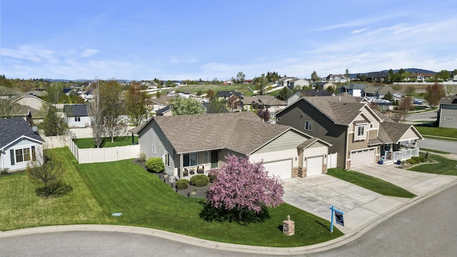view of front of home with an attached garage, driveway, stone siding, and a front lawn