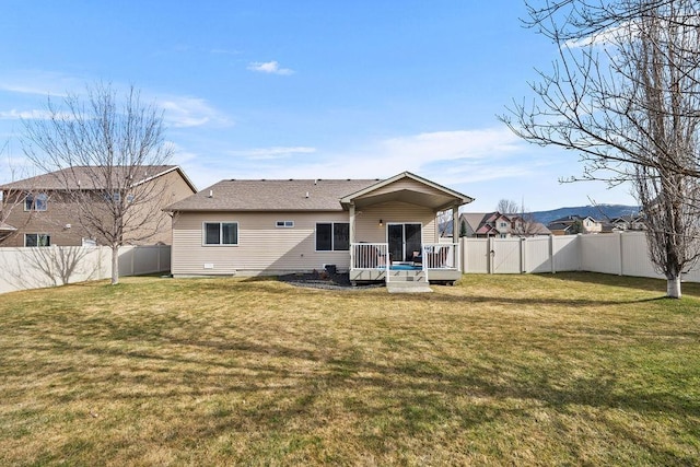 rear view of property with a yard, a wooden deck, and a fenced backyard