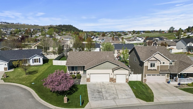 ranch-style house with fence, a front yard, a shingled roof, concrete driveway, and an attached garage