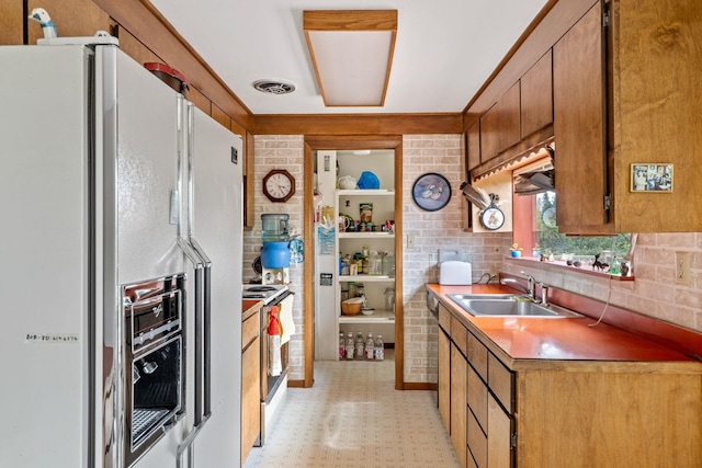 1791 S Leclerc Rd, Newport, WA 99156 - kitchen with white appliances, light flooring, a sink, decorative backsplash, and brown cabinets