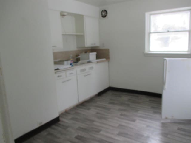 1914 W 8th Ave, Spokane, WA 99204 - kitchen with white cabinetry, light countertops, light wood finished floors, and open shelves