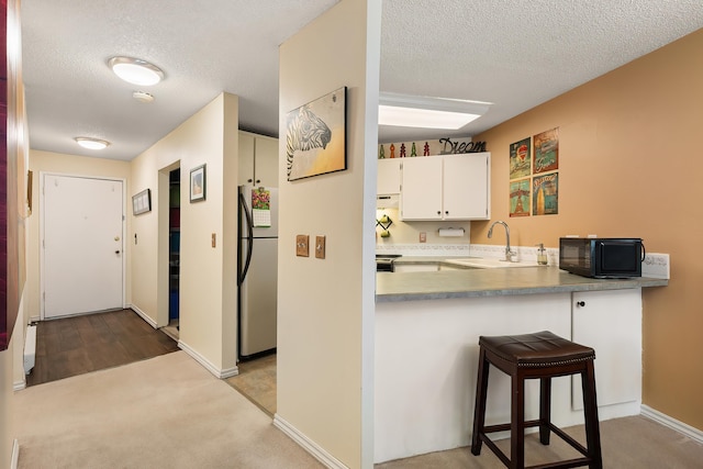 10321 E Main Ave Ste 104, Spokane, WA 99206 - kitchen with black microwave, a textured ceiling, a sink, and freestanding refrigerator