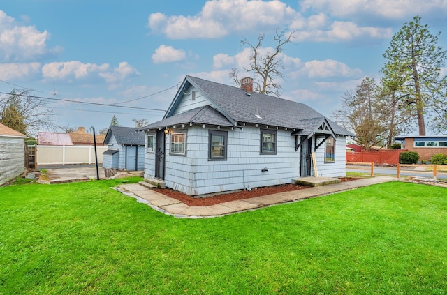 2337 W Kiernan Ave, Spokane, WA 99205 - rear view of property featuring a yard, fence, a chimney, and roof with shingles
